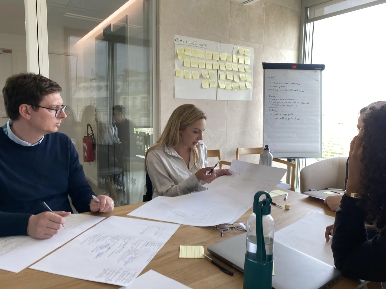 Ideation workshop with the squad — user needs on sticky notes, persona on the flipchart
